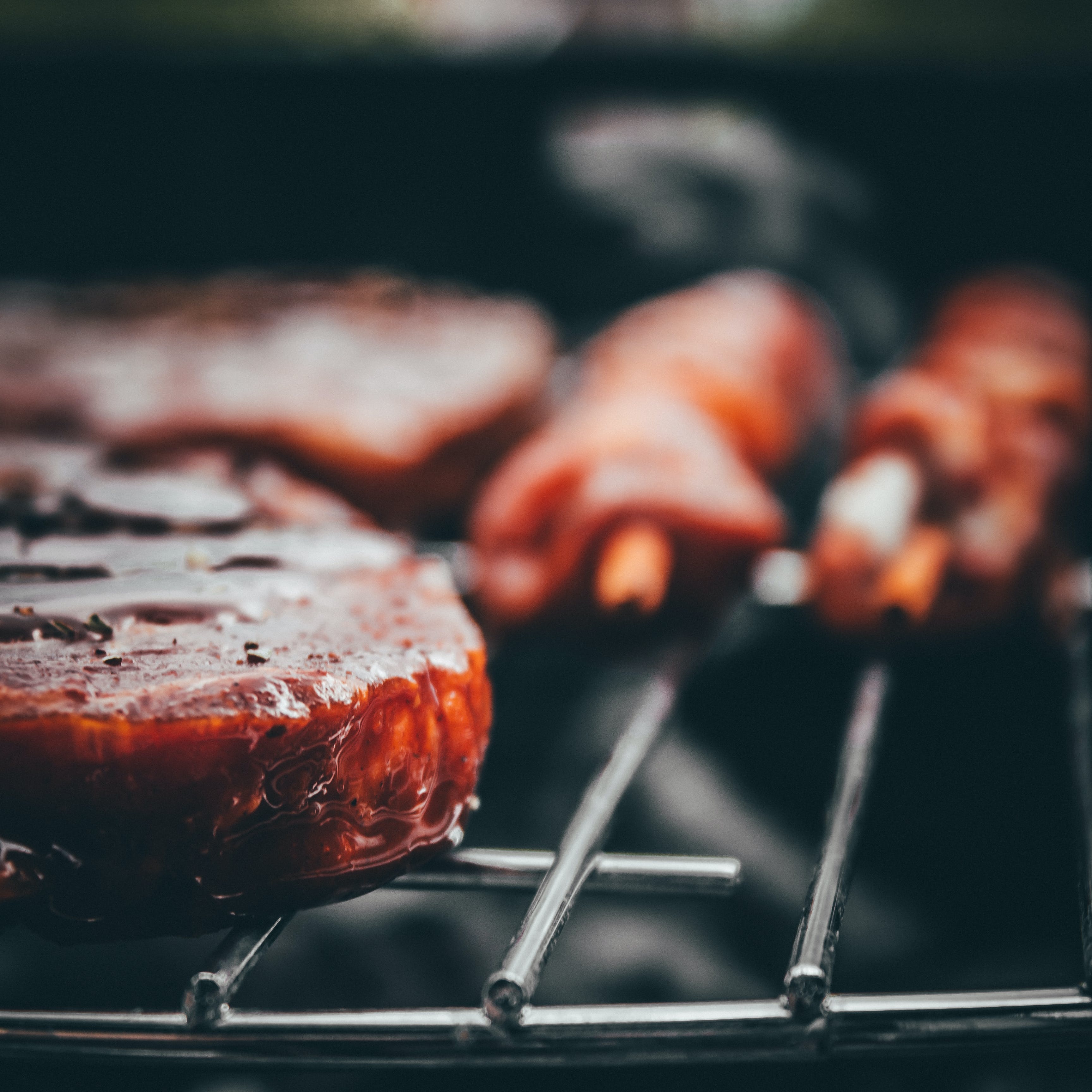 A blurry picture of meat being cooked on a grill.