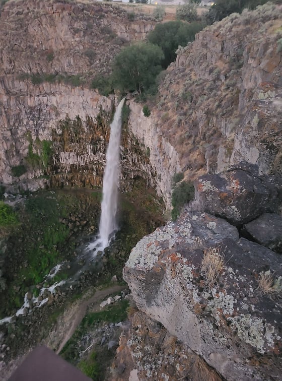 A picture of a waterfall cascading down a large rocky cliff.