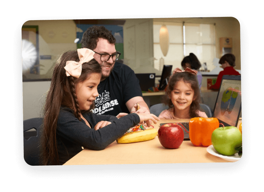 Children playing with fruits on a desk